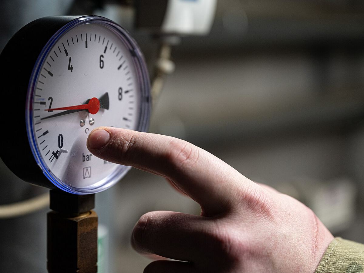 Technician checking a refrigerant pressure gauge